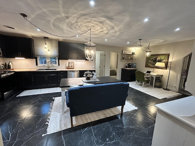 kitchen with a textured ceiling, decorative light fixtures, stainless steel appliances, tasteful backsplash, and sink