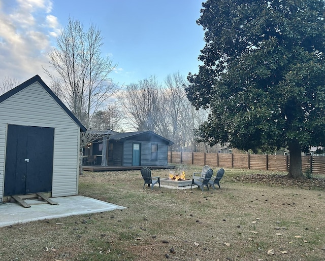 view of yard featuring an outdoor fire pit and a storage shed