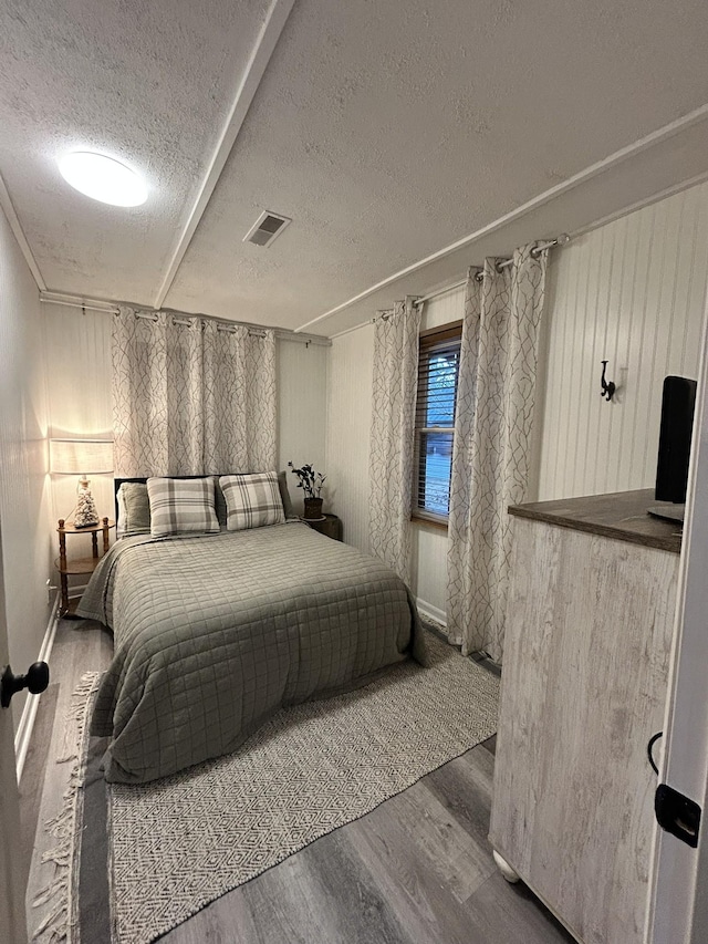 bedroom with a textured ceiling and hardwood / wood-style floors