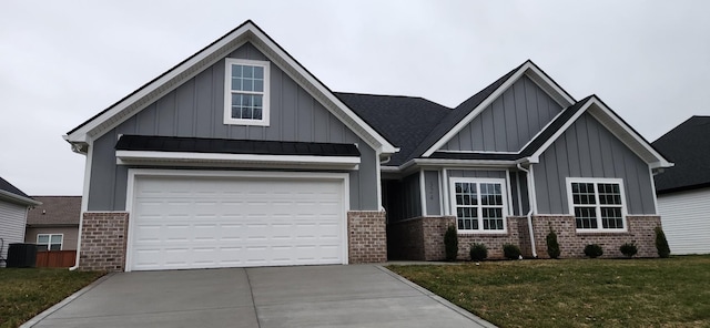 craftsman house with central air condition unit, a front yard, and a garage