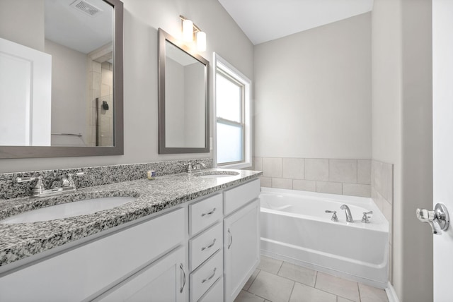 bathroom featuring vanity, tile patterned floors, and a bathing tub