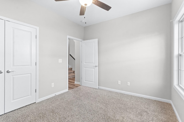 unfurnished bedroom with carpet flooring, ceiling fan, and a closet