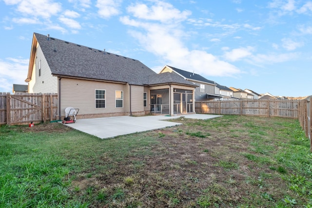 back of house with a yard, a sunroom, and a patio area