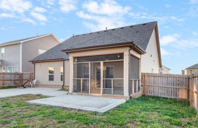 rear view of property featuring a patio area, a yard, and a sunroom