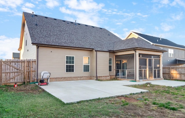 back of house featuring a patio, a yard, and a sunroom