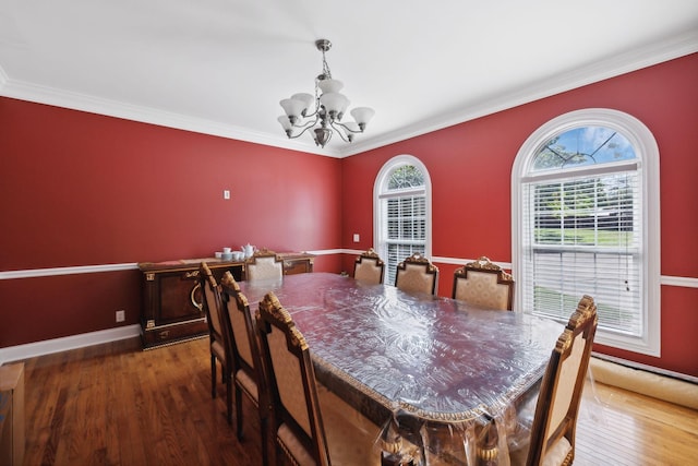 dining area with a chandelier, hardwood / wood-style floors, and crown molding