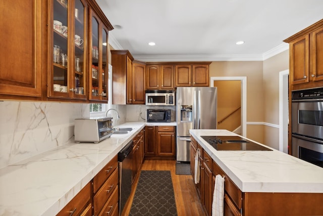 kitchen featuring dark wood-type flooring, black appliances, backsplash, ornamental molding, and sink