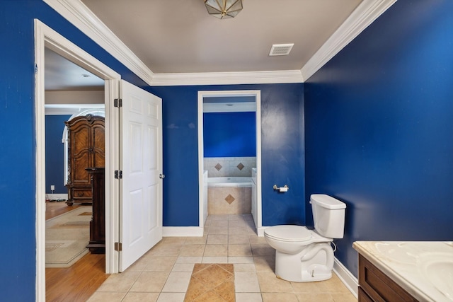 bathroom with toilet, tiled bath, ornamental molding, and tile patterned floors