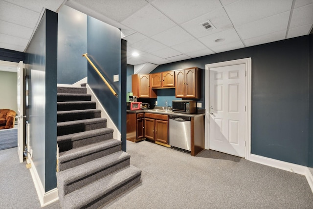 kitchen featuring sink, a paneled ceiling, dishwasher, and light carpet