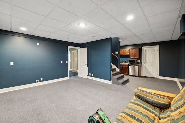 basement with a paneled ceiling and carpet