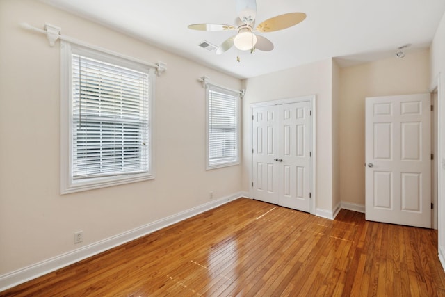 unfurnished bedroom with hardwood / wood-style floors, a closet, and ceiling fan