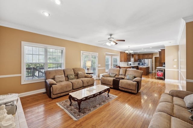 living room featuring ceiling fan, light wood-type flooring, a wealth of natural light, and ornamental molding