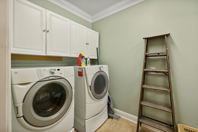 clothes washing area featuring cabinets, washing machine and dryer, crown molding, and light tile patterned floors