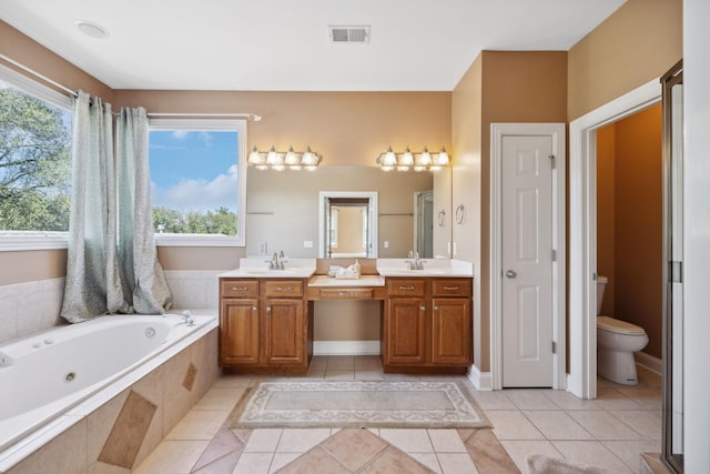 full bathroom featuring toilet, vanity, tile patterned floors, and a healthy amount of sunlight