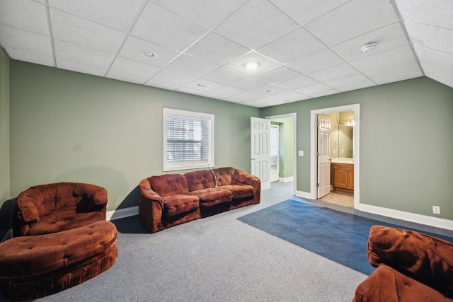 carpeted living room featuring a drop ceiling