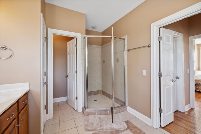 bathroom with an enclosed shower, vanity, and tile patterned floors