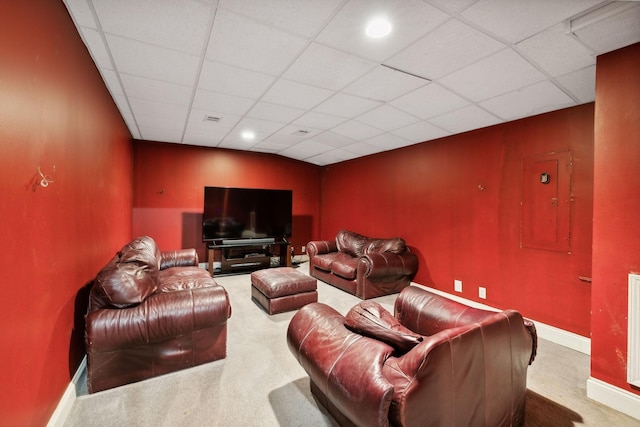 carpeted home theater room featuring a drop ceiling