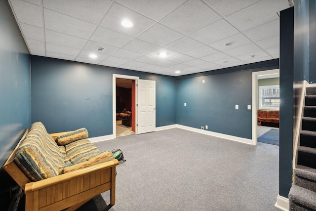 sitting room with a paneled ceiling and carpet floors