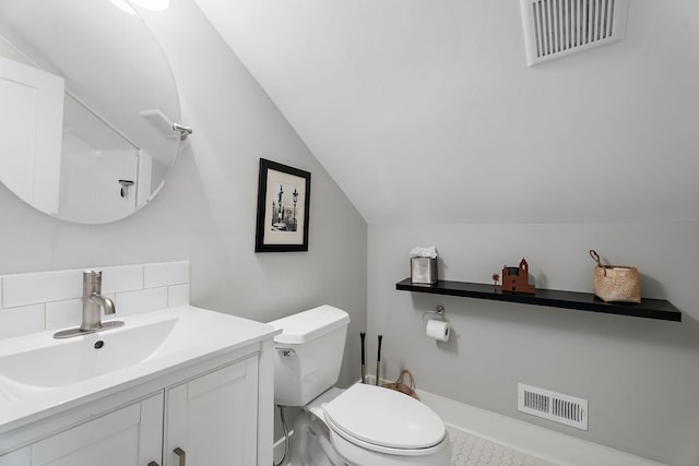 bathroom with toilet, vaulted ceiling, and vanity