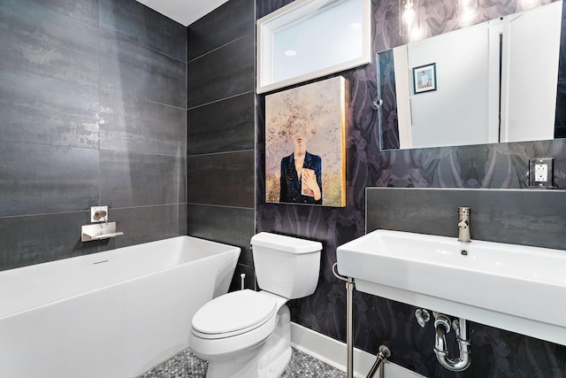 bathroom with sink, tile walls, toilet, tile patterned floors, and a bathtub