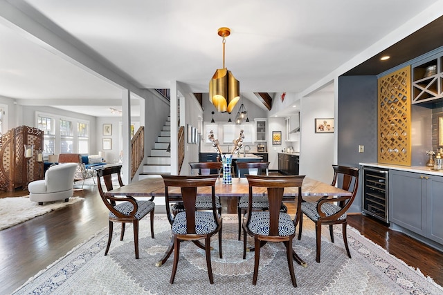 dining area featuring dark wood-type flooring, bar area, a notable chandelier, beverage cooler, and beamed ceiling