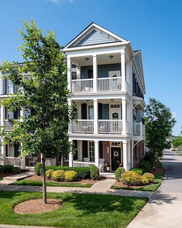 greek revival inspired property with covered porch and a balcony