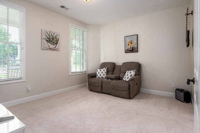 sitting room featuring light carpet and a healthy amount of sunlight