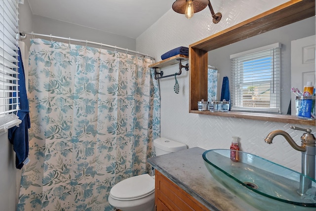 bathroom with toilet, vanity, and a shower with curtain