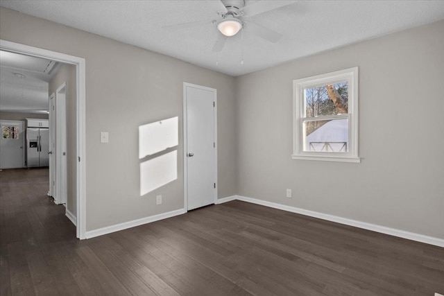 spare room with dark wood-type flooring, a textured ceiling, and ceiling fan