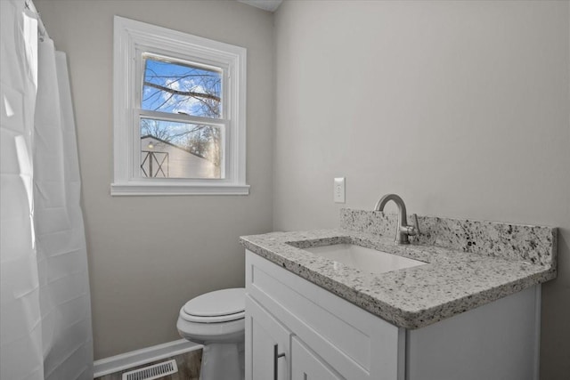 bathroom featuring toilet, wood-type flooring, and vanity