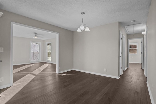 unfurnished room featuring a textured ceiling, ceiling fan with notable chandelier, and dark hardwood / wood-style floors