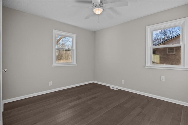 empty room with dark wood-type flooring and ceiling fan