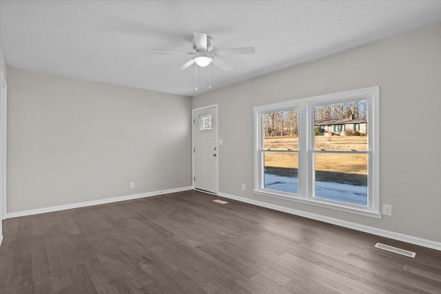 spare room featuring dark wood-type flooring and ceiling fan