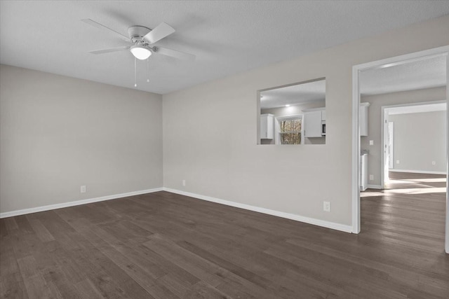 unfurnished room with a textured ceiling, ceiling fan, and dark hardwood / wood-style flooring