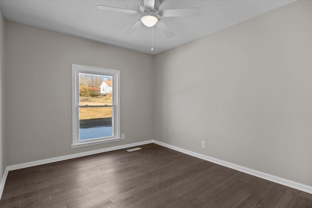 unfurnished room with dark wood-type flooring, a textured ceiling, and ceiling fan