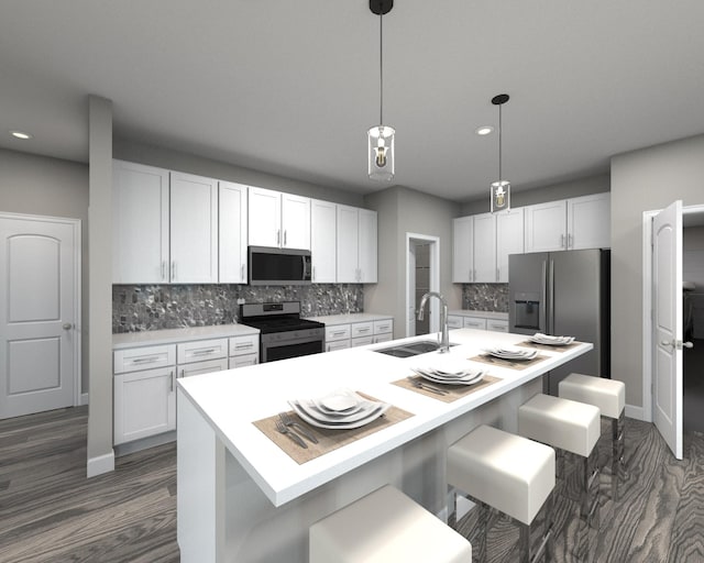 kitchen with sink, decorative light fixtures, white cabinetry, a breakfast bar area, and appliances with stainless steel finishes