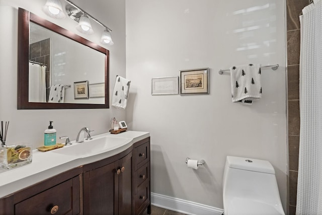 bathroom featuring toilet, vanity, and walk in shower