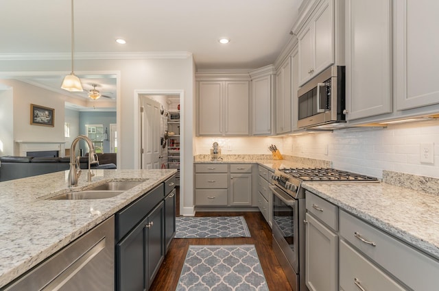 kitchen featuring appliances with stainless steel finishes, gray cabinetry, hanging light fixtures, light stone counters, and sink