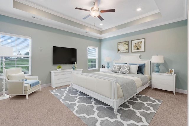 carpeted bedroom featuring a raised ceiling, crown molding, and multiple windows