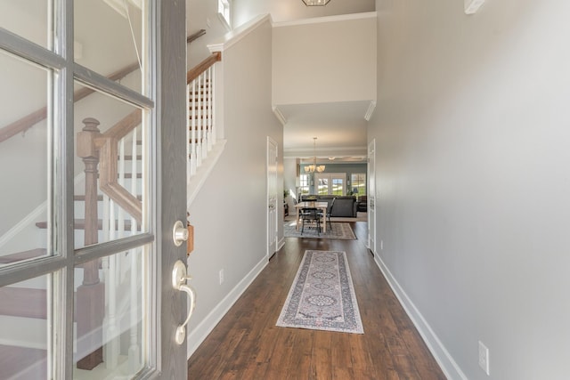 interior space featuring an inviting chandelier, crown molding, dark wood-type flooring, and a towering ceiling