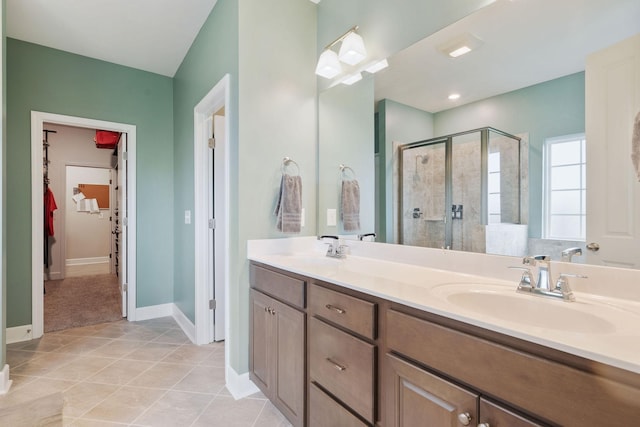 bathroom with a shower with door, vanity, and tile patterned flooring