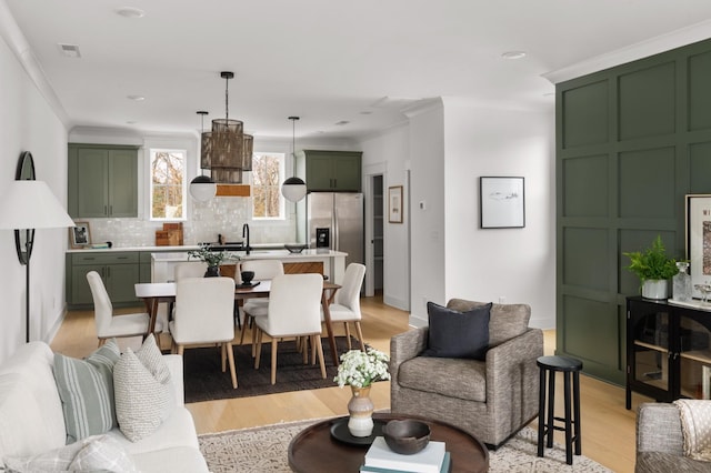 living room featuring ornamental molding and light hardwood / wood-style floors