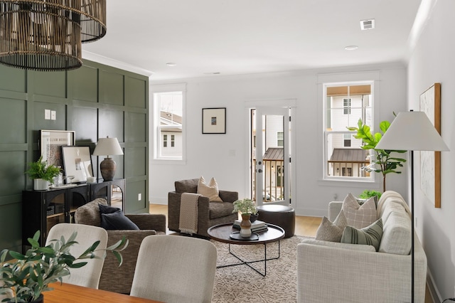 living room featuring ornamental molding and light hardwood / wood-style floors