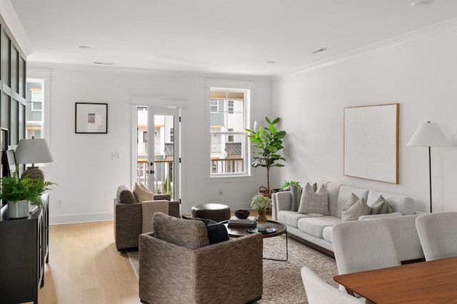 living room featuring light wood-type flooring and ornamental molding