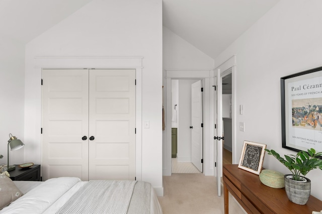 carpeted bedroom featuring a closet and lofted ceiling