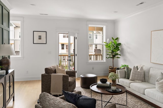 living room with ornamental molding and light hardwood / wood-style flooring