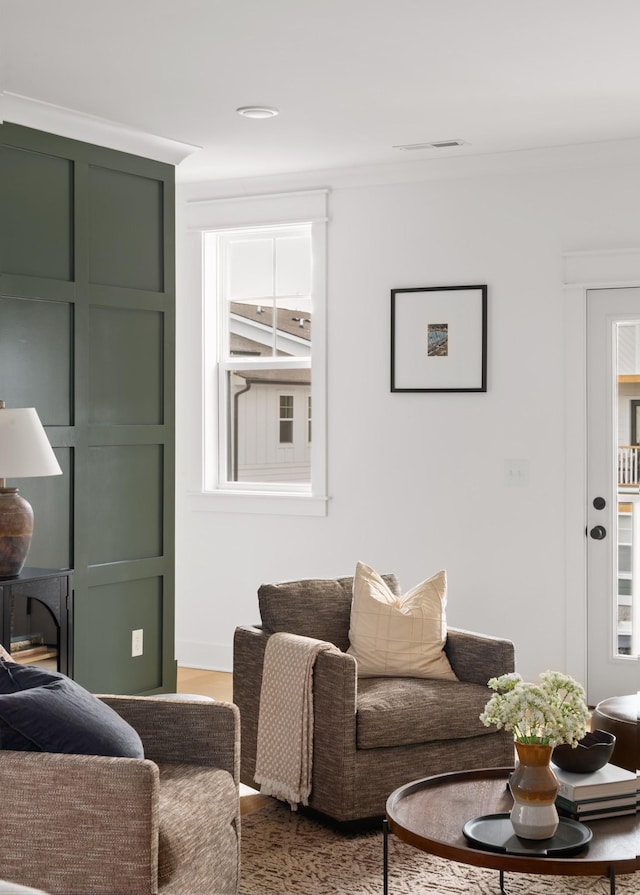 living room with hardwood / wood-style flooring, a healthy amount of sunlight, and crown molding