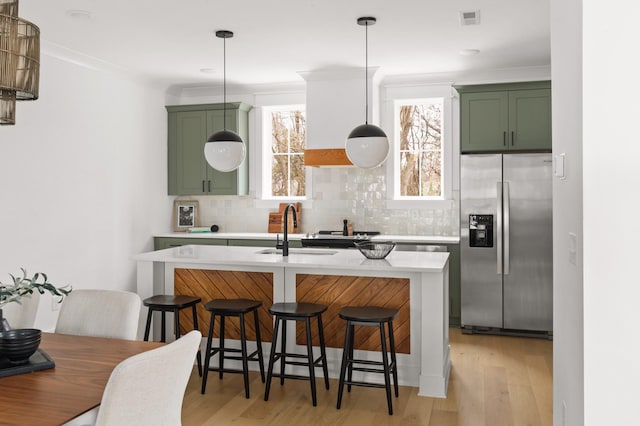 kitchen featuring stainless steel fridge with ice dispenser, green cabinetry, and pendant lighting