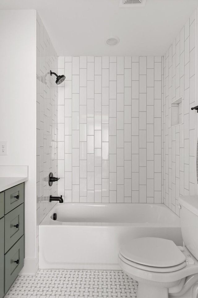 full bathroom featuring toilet, tiled shower / bath, and vanity