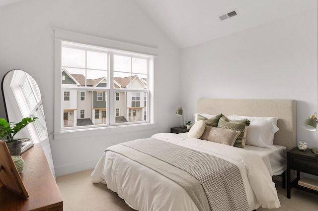 bedroom featuring lofted ceiling, light colored carpet, and multiple windows